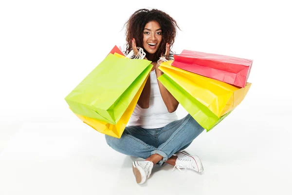 Cheerful young african woman holding shopping bags. — Stock Photo, Image