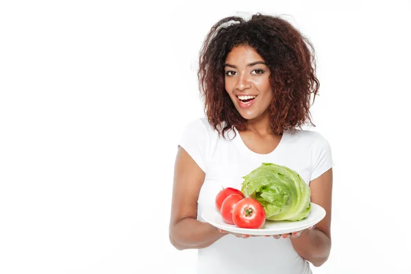 Szczęśliwa młoda kobieta Afryki posiadający warzyw. — Zdjęcie stockowe