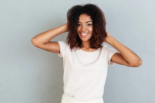 Mulher sorridente posando e brincando com o cabelo em pé — Fotografia de Stock