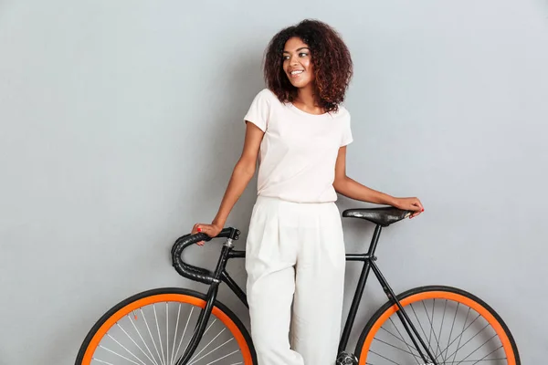Улыбающаяся африканка позирует с велосипедом — стоковое фото
