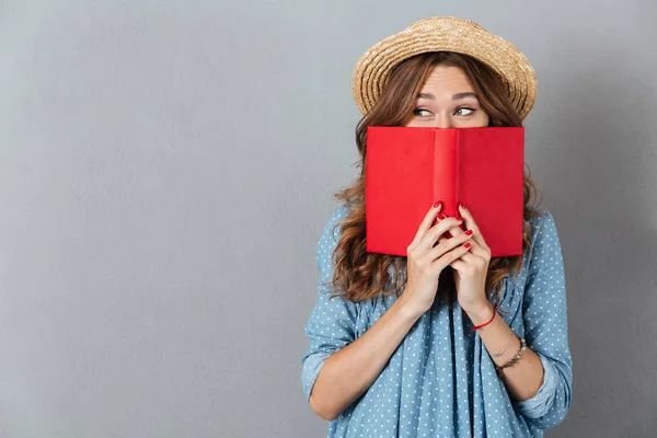 Vrouw over grijs muur dragen hoed bedekking gezicht — Stockfoto