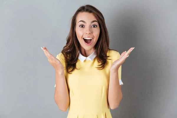 Menina bonita feliz de pé e gesto com as mãos — Fotografia de Stock