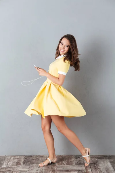 Full length portrait of a smiling pretty girl in dress — Stock Photo, Image