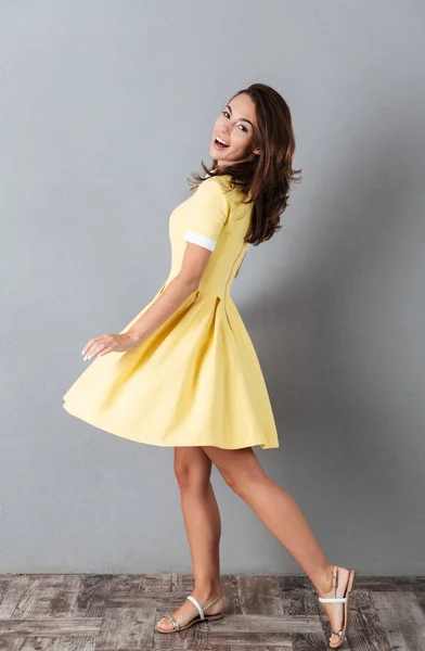 Full längd porträtt av en leende söt flicka i klänning poserar — Stockfoto