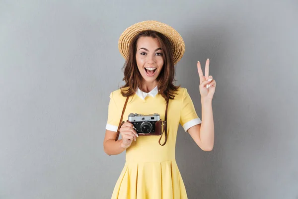 Heureuse jeune fille en chapeau tenant caméra rétro — Photo