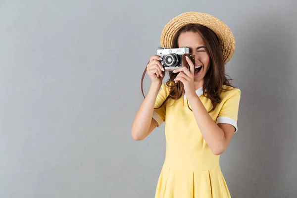 Menina bonita nova no chapéu tirando foto com câmera vintage — Fotografia de Stock