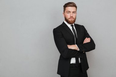 Kendine güvenen genç işadamı silah ile ayakta takım elbiseli katlanmış