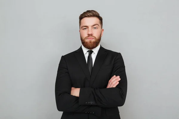 Αυτοπεποίθηση νεαρός επιχειρηματίας στο κοστούμι στέκεται με τα χέρια διπλωμένα — Φωτογραφία Αρχείου