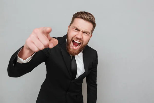 Homem de negócios irritado em terno gritando e apontando o dedo para a câmera — Fotografia de Stock