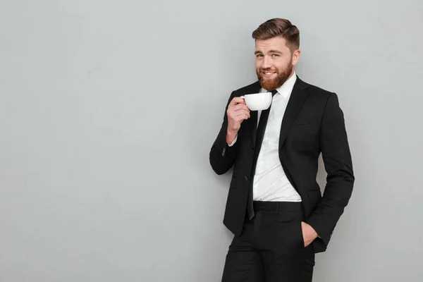 Agradable hombre barbudo fresco en traje beber té — Foto de Stock