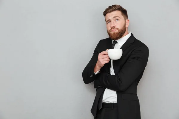 Pensive bearded man in holding cup of coffee — Stock Photo, Image