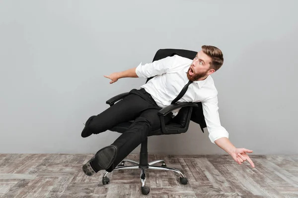 Divertido loco empresario divertirse mientras está sentado en la silla de la oficina —  Fotos de Stock