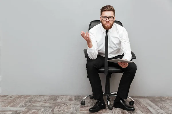 Hombre de negocios frustrado descontento en gafas que sostienen la tableta de PC —  Fotos de Stock