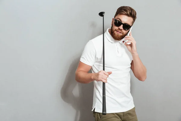 Calma golfista hablando por el teléfono inteligente y club de celebración —  Fotos de Stock