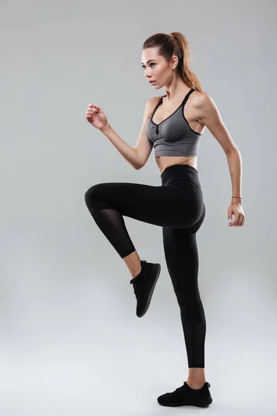 Ganzkörperporträt einer jungen Frau in Sportbekleidung, die posiert — Stockfoto