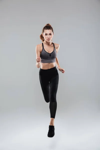 Retrato de comprimento total de uma jovem mulher em sportswear running — Fotografia de Stock