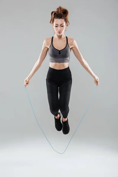 Young healthy fitness woman jumping with a skipping rope — Stock Photo, Image