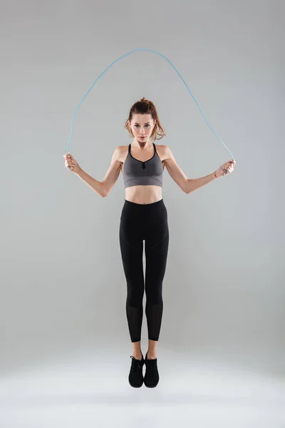 Retrato de cuerpo entero de una mujer sana y segura saltando — Foto de Stock