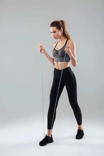 Confident sportswoman doing exercises with a skipping rope — Stock Photo, Image