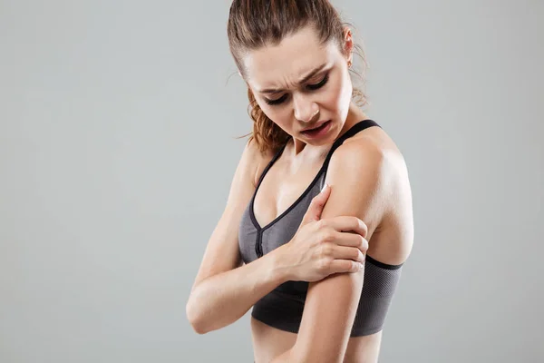 Bijgesneden afbeelding van jonge fitness vrouw met arm pijn — Stockfoto