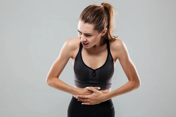 Giovane donna di idoneità che soffre di mal di stomaco — Foto Stock