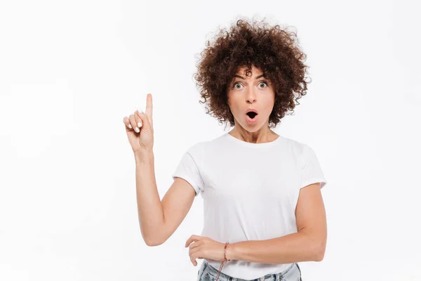 Mujer joven emocionada teniendo una idea y señalando con el dedo hacia arriba — Foto de Stock