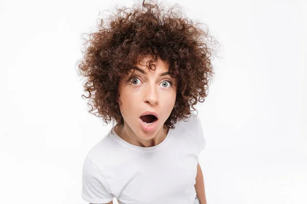 Nahaufnahme einer verblüfften jungen Frau mit lockigem Haar — Stockfoto