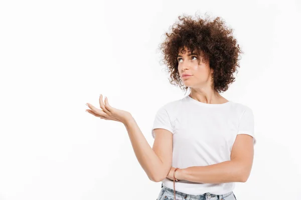 Jovem mulher casual com cabelo encaracolado segurando copyspace — Fotografia de Stock