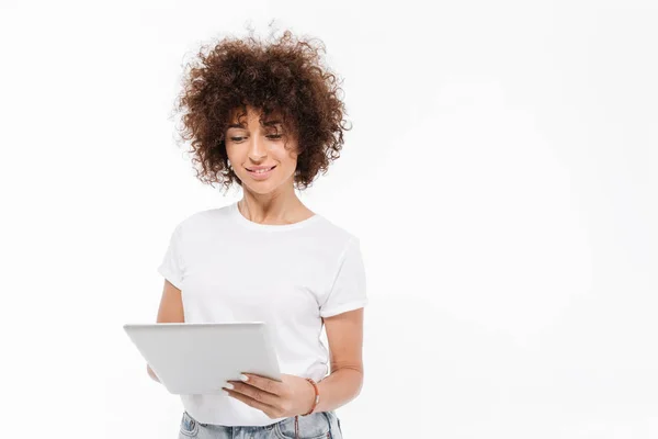 Χαμογελώντας casual γυναίκα στέκεται και χρησιμοποιώντας υπολογιστή tablet — Φωτογραφία Αρχείου