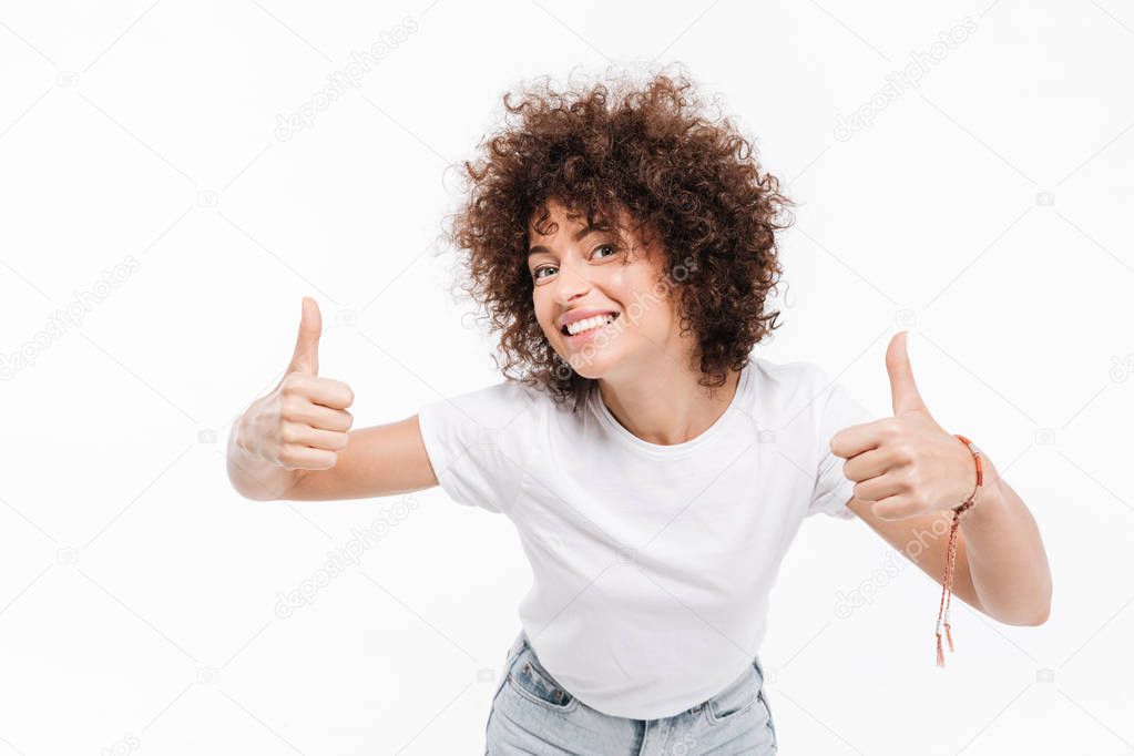 Happy smiling girl with curly hair showing two thumbs up