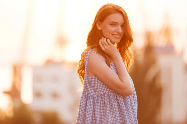 Beauty Young Ginger girl in dress posing sideways on sunset — Stock Photo, Image