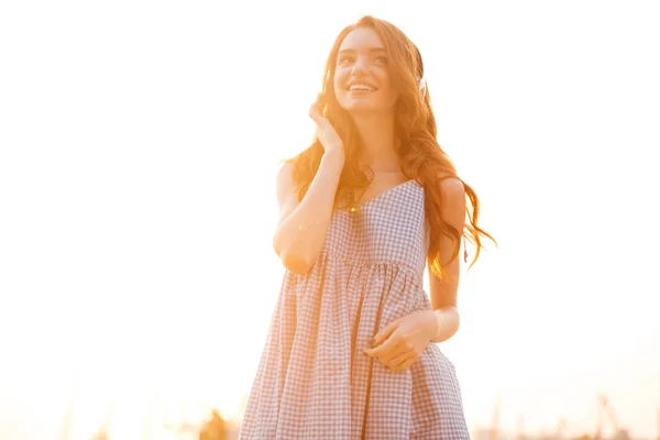 Sonriente mujer de jengibre de belleza en vestido escuchando música — Foto de Stock