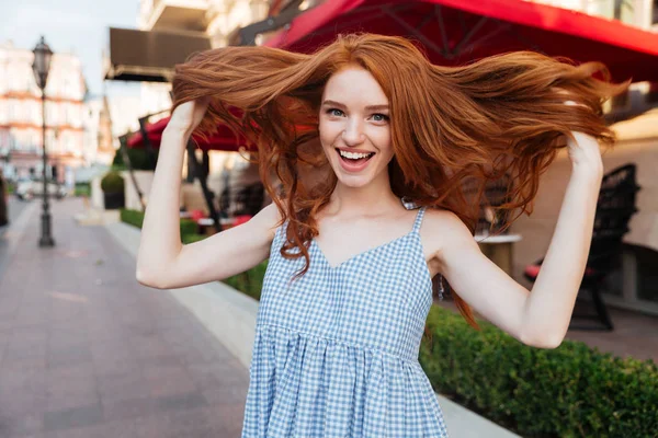 Aantrekkelijke jonge meisje speelt met haar haren — Stockfoto