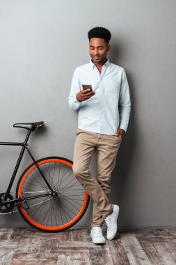 Neşeli genç Afrika adam gri duvar sohbet üzerinde ayakta