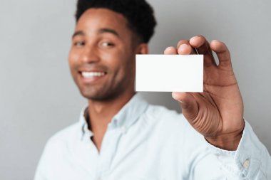 Gülümseyen genç afro Amerikan adam boş kartvizit gösterilen