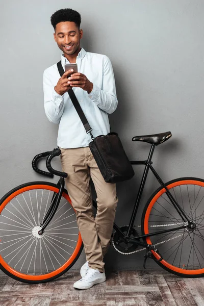 Afrika adam Bisiklet telefonla sohbet yanında ayakta.