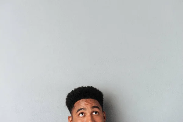 Halva ansiktet av en afrikansk man tittar upp på kopia utrymme — Stockfoto