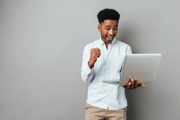 Ενθουσιασμένος ευτυχισμένη afro Αμερικανός άνδρας ψάχνει στο φορητό υπολογιστή — Φωτογραφία Αρχείου