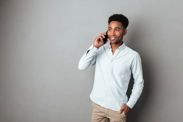 Aantrekkelijke jonge Afrikaanse man praten op mobiele telefoon terwijl je — Stockfoto