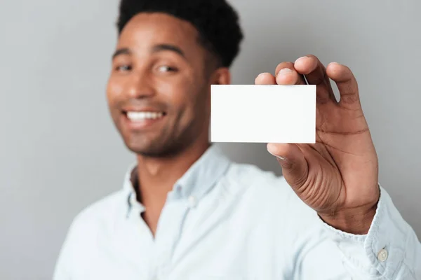 Zâmbind tânăr afro-american tip care arată carte de vizită goală — Fotografie, imagine de stoc