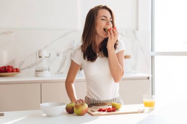 Genç ve güzel kadın yemek pişirme sırasında elma