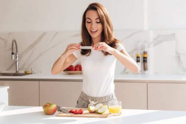 Meyve dilimleri fotoğrafını mutlu gülümseyen kadın