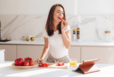 Gülümseyen neşeli kadın bir salata yaparken sebze yemek