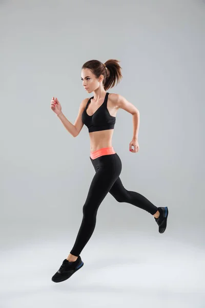 Imagen completa de una mujer deportiva corriendo en el estudio —  Fotos de Stock