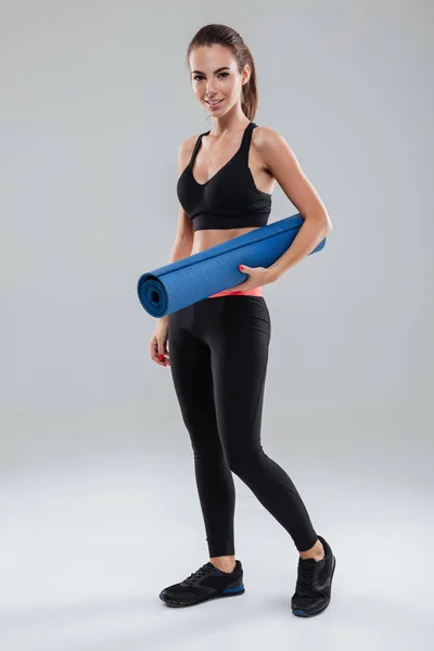 Volle lengte foto van lachende fitness vrouw met fitness mat — Stockfoto