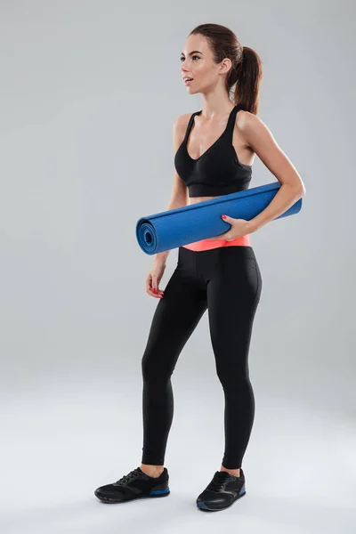 Volledige lengte beeld van verrast fitness vrouw met fitness mat — Stockfoto