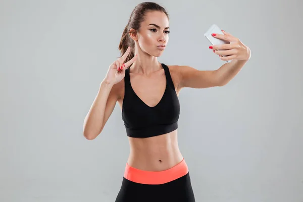 Fiatal komoly fitness nő, ami selfie a smartphone — Stock Fotó