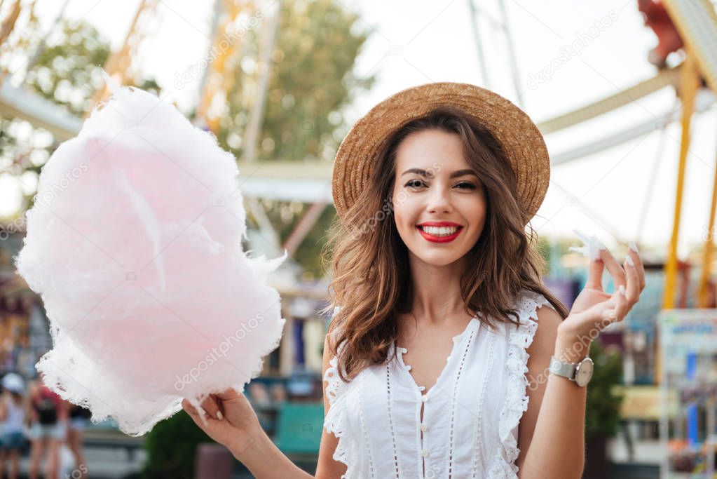 Happy smiling girl with cotton candy at the park