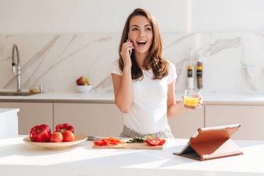 Pişirme sırasında cep telefonu üzerinde konuşurken mutlu heyecanlı kadın