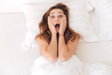 Şok genç kadın yatakta yatan bir Üstten Görünüm